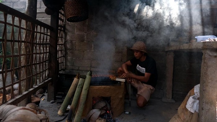 Koki menyajikan ikan timbungan atau hidangan tradisional khas Bali kepada wisatawan di Dapur Bali Mula, Desa Les Tejakula, Buleleng, Bali, Kamis (29/6/2023). Warung kuliner yang mengusung konsep dapur tradisional Bali tersebut menjadi daya tarik bagi wisatawan untuk berkunjung dan menerapkan sistem pembayaran secara sukarela. ANTARA FOTO/Nyoman Hendra Wibowo/hp.