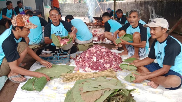 Warga RT 1 RW 2, Desa Kracak, Kecamatan Ajibarang, Kabupaten Banyumas mengemas daging kurban dengan daun jati, Kamis (29/6/2023).