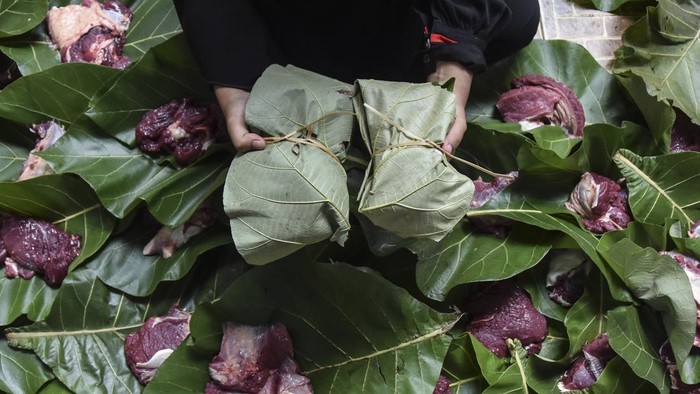 Sejumlah santri membungkus daging kurban dengan daun kayu jati di Pondok Pesantren Laskar Langit, Desa Margaluyu, Kabupaten Tasikmalaya, Jawa Barat, Jumat (30/6/2023). Ponpes tersebut sejak tahun 2013 telah membuat kebijakan mengemas daging kurban menggunakan daun jati dan tali bambu untuk mendukung program pemerintah peduli terhadap lingkungan serta menghindari penggunaan kantong plastik. ANTARA FOTO/Adeng Bustomi/nym.