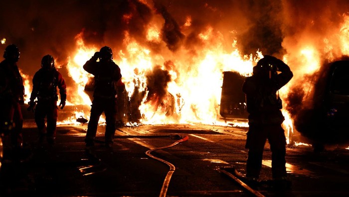 French police stand in position as fireworks go off during clashes with youth, after the death of Nahel, a 17-year-old teenager killed by a French police officer during a traffic stop, in Nanterre, Paris suburb, France, June 30, 2023. REUTERS/Gonzalo Fuentes     TPX IMAGES OF THE DAY