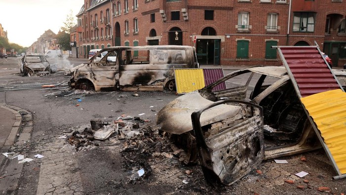 View of a street with cars, burnt during night clashes between protesters and police, following the death of Nahel, a 17-year-old teenager killed by a French police officer in Nanterre during a traffic stop, at the Alma district in Roubaix, northern France, June 30, 2023. REUTERS/Pascal Rossignol