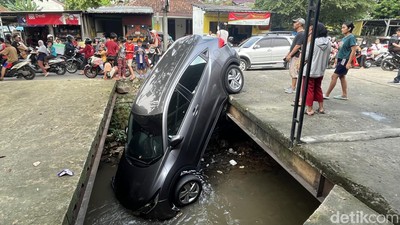Mobil Nyungsep di Kali Depok Jadi Tontonan Warga