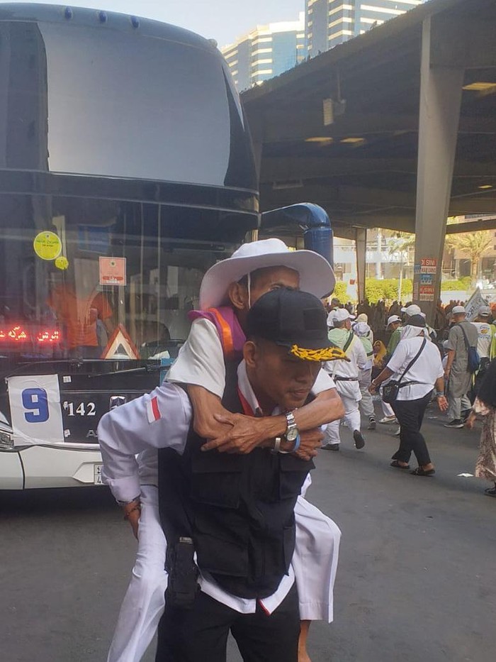 Petugas mengawal jemaah haji berjalan ke hotel