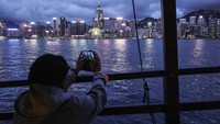Wisatawan memotret pemandangan kota dari atas kapal wisata saat menyusuri kawasan Pelabuhan Victoria. Gimana detikers, tertarik mencoba? 