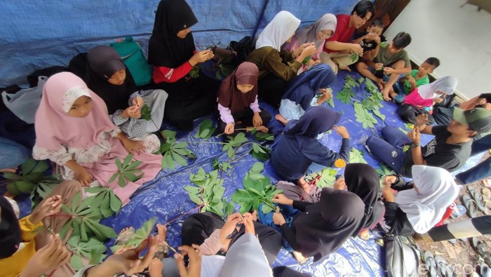 Anak-anak terlihat ceria membuat boneka menyerupai wayang dari daun singkong.