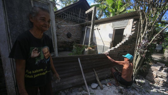 Dampak gempa bumi di Bantul Warga memasang seng untuk menutupi dinding yang roboh akibat gempa bumi di Sanden, Bantul, D.I Yogyakarta, Sabtu (1/7/2023). Badan Penanggulangan Bencana Daerah (BPBD) Kabupaten Bantul, Daerah Istimewa Yogyakarta (DIY), menyatakan gempa bumi dengan magnitudo 6,4 pada Jumat (30/6) pukul 19:57:43 WIB yang kemudian dimutakhirkan menjadi M6,0 menyebabkan dampak kerusakan pada 57 bangunan yang didominsasi genteng melorot dan dinding retak di 12 kecamatan daerah itu. ANTARA FOTO/Andreas Fitri Atmoko/aww.