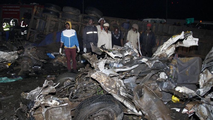 Kenya Road Accident People stand near the wreckage of vehicles after a fatal accident in Londiani, Kenya early Saturday, July 1, 2023, at a location known for crashes about 200 kilometers (125 miles) northwest of the capital, Nairobi. Dozens were killed when a truck rammed into several other vehicles and market traders on Friday evening, police said. (AP Photo)