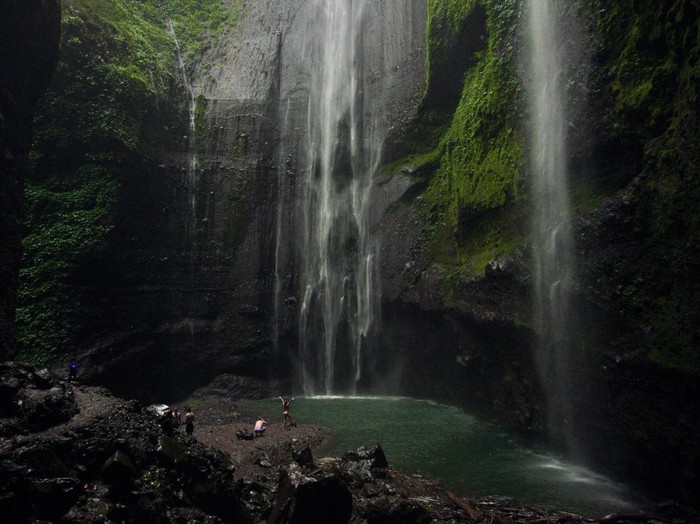 Wisatawan berjalan di bebatuan saat mengunjungi Air Terjun Madakaripura di Probolinggo, Jawa Timur, Jumat (30/6/2023). Pada libur Idul Adha, kunjungan wisatawan di air terjun tersebut meningkat hingga 100 pengunjung per hari dibanding hari biasa yang hanya mencapai 36 orang per hari. ANTARA FOTO/Irfan Sumanjaya/rwa.
