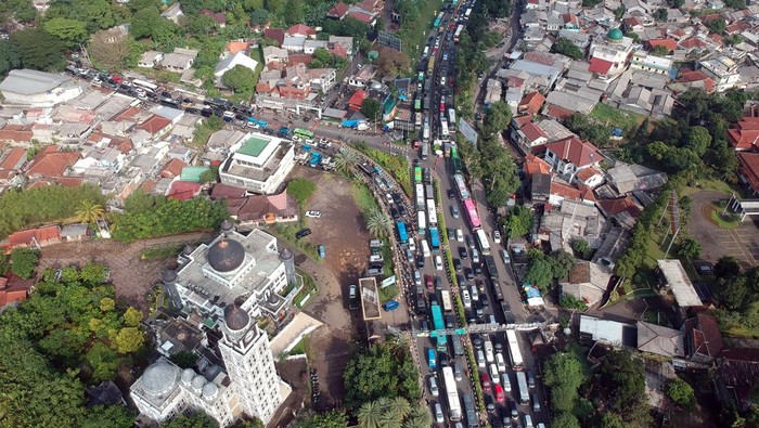Foto udara kepadatan kendaraan di Simpang Gadog menuju kawasan wisata Puncak, Kabupaten Bogor,  Jawa Barat, Sabtu (1/7/2023). Polres Bogor memprediksi pada hari Sabtu (1/7) sebagai puncak arus liburan Idul Adha 1444 Hijriah sehingga pihak kepolisian  memberlakukan rekayasa lalu lintas sistem satu arah, sistem lawan arus di keluar Tol Ciawi serta ganjil genap kendaraan menuju kawasan wisata Puncak Bogor, untuk mengantisipasi terjadinya kemacetan. ANTARA FOTO/Yulius Satria Wijaya/aww.