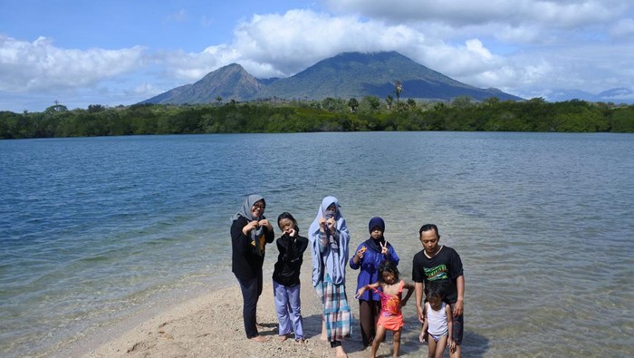 Anak-anak bermain pasir dengan latar belakang Gunung Baluran di Pantai Sijile, Banyuputih, Situbondo, Jawa Timur, Sabtu (1/7/2023). Kunjungan wisatawan ke pantai itu meningkat seiring perbaikan akses menuju kawasan, seperti saat libur panjang Idul Adha 1444 Hijriah berkisar 300 orang per hari daripada sebelumnya 20 orang per hari. ANTARA FOTO/Seno/aww.