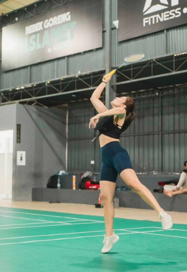 Kali ini saat Wulan Guritno pergi ke Yogyakarta, pilihan celana ketat pendek dan crop top hitam membuatnya mudah bergerak saat bermain badminton. Foto: Instagram @wulanguritno