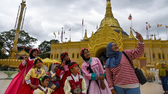 Sejumlah warga berkunjung di Taman Alam Lumbini, Karo, Sumatera Utara, Minggu (2/7/2023). Taman seluas tiga hektare tersebut memiliki pagoda mirip Pagoda Shwedagon Myanmar yang merupakan pagoda tertinggi di Indonesia dan dilengkapi penyewaan busana tradisional Korea sehingga menjadi daya tarik bagi wisatawan saat berkunjung ke objek wisata religi tersebut. ANTARA FOTO/Fransisco Carolio/nym.