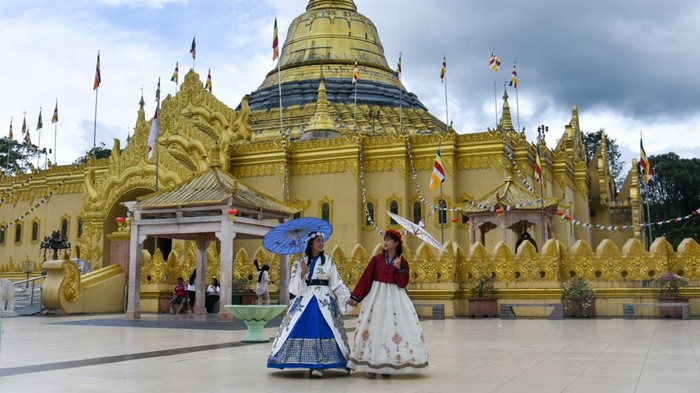 Wisata taman alam Lumbini Sejumlah warga berkunjung di Taman Alam Lumbini, Karo, Sumatera Utara, Minggu (2/7/2023). Taman seluas tiga hektare tersebut memiliki pagoda mirip Pagoda Shwedagon Myanmar yang merupakan pagoda tertinggi di Indonesia dan dilengkapi penyewaan busana tradisional Korea sehingga menjadi daya tarik bagi wisatawan saat berkunjung ke objek wisata religi tersebut. ANTARA FOTO/Fransisco Carolio/nym.