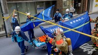 Orang yang terluka dievakuasi dari lokasi ledakan di dekat stasiun Shimbashi di Tokyo.  