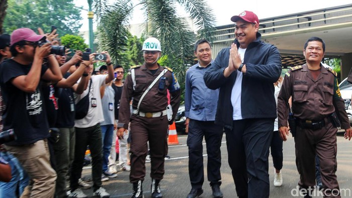Berjaket Hitam dan Topi Merah, Menpora Penuhi Panggilan Kejagung Menpora Dito Ariotedjo memenuhi pemanggilan Kejagung untuk diperiksa sebagai saksi kasus korupsi BTS Kominfo, Senin (3/7/2023). Dito datang dengan mengenakan jaket hitam.