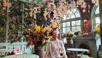 Tak hanya restoran saja, ada juga momen Della Puspita saat nongkrong cantik di kafe kekinian. Kafenya dipenuhi dengan bunga-bunga di setiap sudut. Foto: Instagram @dellapuspita00