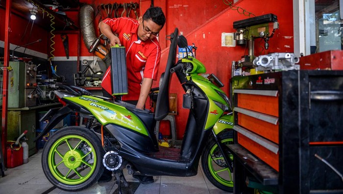 Mekanik melepas baterai motor bbm yang dikonversi ke motor listrik di bengkel Bacip Moto Shop di Bandung, Jawa Barat, Senin (3/7/2023). Bengkel Bacip Moto Shop binaan Bintang Racing Team tersebut merupakan bengkel resmi pemasangan, perawatan, pemeriksaan peralatan instalasi sistem penggerak motor listrik pada kendaraan bermotor dan mendapatkan lisensi Kementerian Perhubungan. Konversi motor tersebut dipatok dengan harga Rp9, 5 juta dengan jarak tempuh rata-rata 40 kilometer. ANTARA FOTO/Raisan Al Farisi/nz