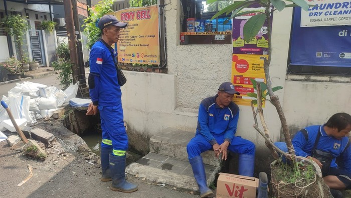 Pasukan biru Dinas SDA menutup permukaan got yang tercemari kotoran sapi di Cikoko, Pancoran, Jaksel, 3 Juli 2023. (Sumber: Warga bernama Hasan Alhabsy)
