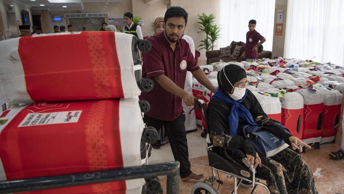Dua petugas menata koper jamaah haji Indonesia kloter UPG 1 untuk ditimbang di Hotel 301 di Mekah, Arab Saudi, Minggu (2/7/2023). Sebanyak delapan kloter akan diterbangkan perdana kembali ke tanah air usai mengikuti pelaksanaan puncak ibadah haji. ANTARA FOTO/Wahyu Putro A/nz