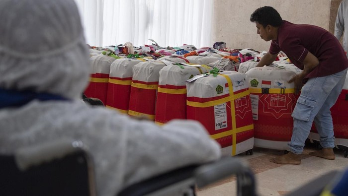 Potret Persiapan Kepulangan Kloter Perdana Jemaah Haji RI Dua petugas menata koper jamaah haji Indonesia kloter UPG 1 untuk ditimbang di Hotel 301 di Mekah, Arab Saudi, Minggu (2/7/2023). Sebanyak delapan kloter akan diterbangkan perdana kembali ke tanah air usai mengikuti pelaksanaan puncak ibadah haji. ANTARA FOTO/Wahyu Putro A/nz