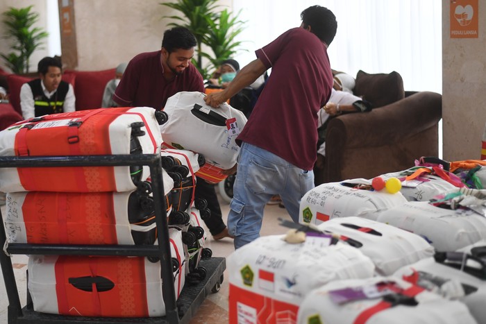 Dua petugas menata koper jamaah haji Indonesia kloter UPG 1 untuk ditimbang di Hotel 301 di Mekah, Arab Saudi, Minggu (2/7/2023). Sebanyak delapan kloter akan diterbangkan perdana kembali ke tanah air usai mengikuti pelaksanaan puncak ibadah haji. ANTARA FOTO/Wahyu Putro A/nz
