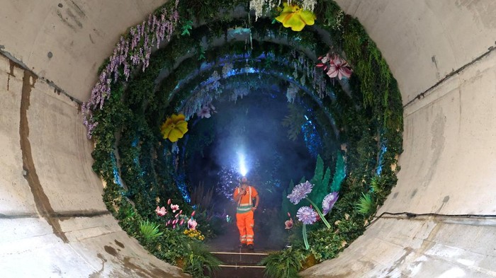 Proyek Gorong-gorong Disulap Jadi Taman Cantik Soroti Isu Lingkungan Engineer Jason Lyon poses as he views Loo Garden, a temporary subterranean garden designed to represent a future healthier River Thames, in a section of the Thames Tideway Tunnel - commonly known as the 'Super Sewer' - a 25 kilometre tunnel being built across London under and along the River Thames to deal with combined sewer overflows currently polluting the river, in London, Britain, June 29, 2023. REUTERS/Toby Melville