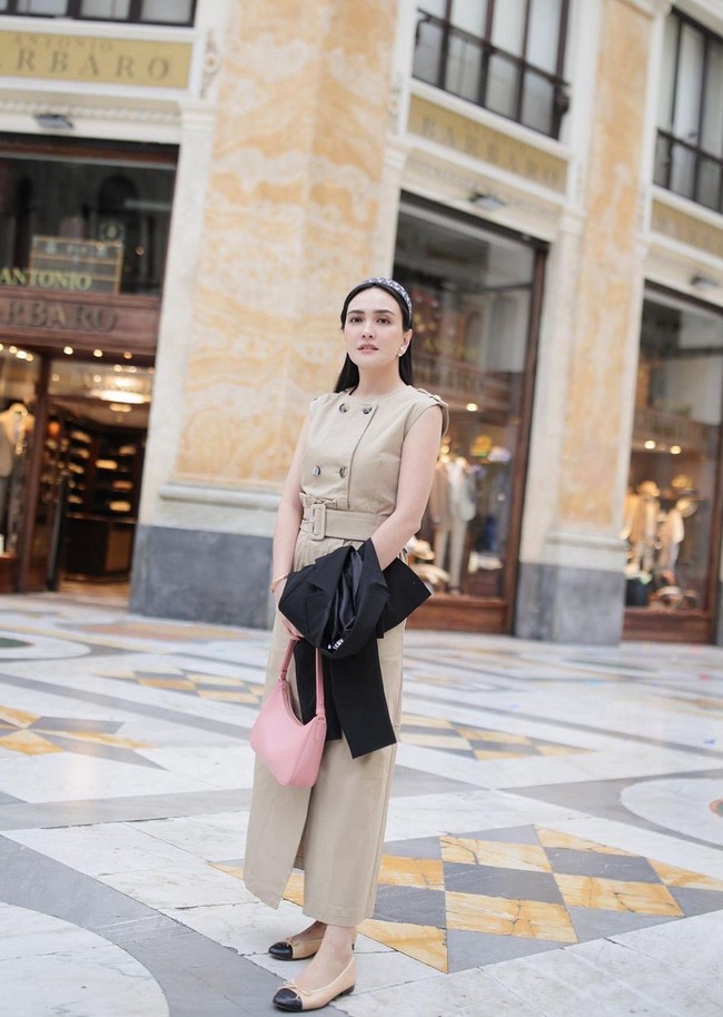 Terusan warna krem membuatmu terlihat lebih chic dan sophisticated dengan padanan blazer hitam. Berikan percikan warna pink pada aksesori seperti tas atau sepatu. Jangan lupakan juga perhiasan anting atau gelang sebagai statement gaya. Foto: Instagram/@shandyaulia