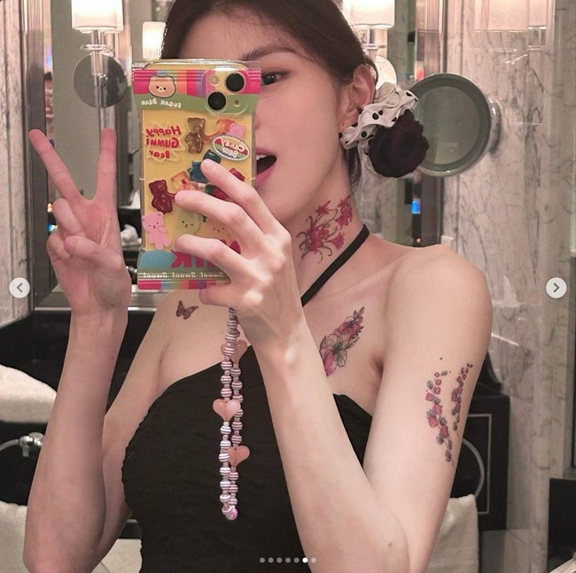 Tampil dalam balutan halter tanktop, Han So Hee mengekspos tato yang menghiasi area leher, lengan, dan dada bagian atas. Foto: dok. Instagram @xeesoxee