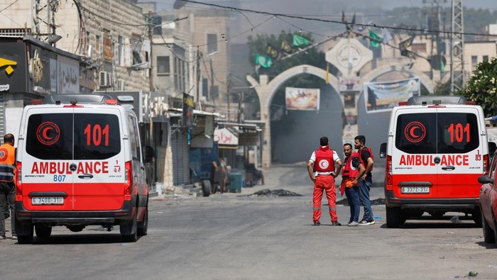 Israel Bombardir Kamp Jenin, 9 Warga Palestina Tewas Palestinian medics stand by as smoke rises during an Israeli military operation in Jenin, in the Israeli-occupied West Bank July 3, 2023. REUTERS/Mohamad Torokman