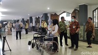 Petugas PPIH dengan sigap membantu menurunkan koper serta membantu jemaah haji turun dari bus. Kursi roda pun sudah disiapkan bagi jemaah lansia. Foto: Devi Setya/detikHikmah