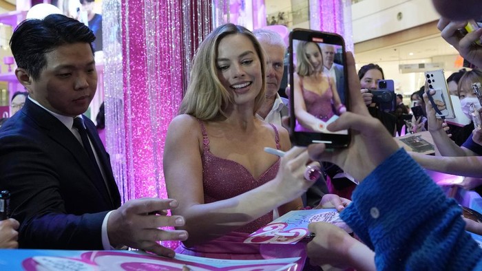 Margot Robbie signs autographs for fans during the pink carpet event for the movie Barbie in Seoul, South Korea, Sunday, July 2, 2023. The film is to be released in the country on July 19. (AP Photo/Ahn Young-joon)