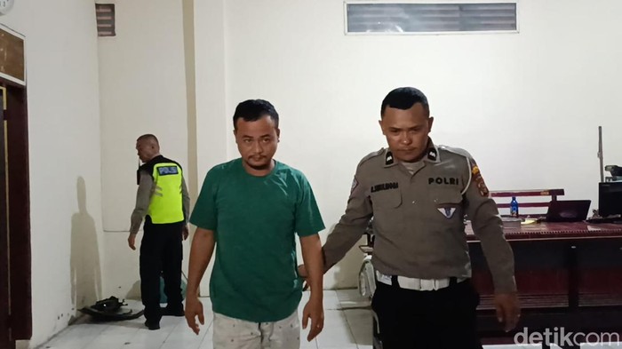 Nofirius Waruwu (kaos hijau) saat berada di Satlantas Polrestabes Medan. (Goklas Wisely/detikSumut)
