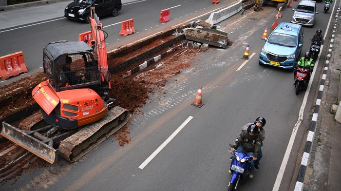 Penataan Jalan HR Rasuna Said Pengguna jalan melintasi proyek pembongkaran pembatas Jalan HR Rasuna Said di Kuningan, Jakarta, Selasa (4/7/2023). Penataan Jalan HR Rasuna Said itu dilakukan untuk mempercantik dan memperlancar pengguna jalan yang melintas. ANTARA FOTO/Akbar Nugroho Gumay/rwa.