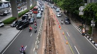 Pengguna jalan melintasi proyek pembongkaran pembatas Jalan HR Rasuna Said di Kuningan, Jakarta, Selasa (4/7/2023).  