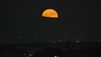 Bulan super terbit di langit malam di atas Roma, Italia. Bulan ini disebut supermoon karena berada lebih dekat dengan bumi daripada biasanya. Para pengamat juga menyatakan selama fenomena berlangsung, bulan juga akan berada di posisi yang lebih rendah daripada waktu lainnya. AP/Alessandra Tarantino.