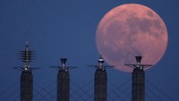 Bulan Buck Moon terlihat di atas tiang penyangga di pusat konvensi Bartle Hall di Kansas City, Senin (3/7/2023). Fenomena ini menjadi supermoon pertama dari empat fenomena bulan penuh yang bakal terjadi di tahun 2023. AP/Charlie Riedel.
