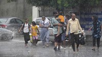 Mereka berjalan tanpa mengenakan payung maupun jas hujan.  