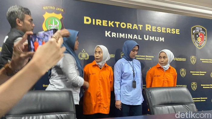 Si kembar penipu, Rihana dan Rihani berbaju tahanan.