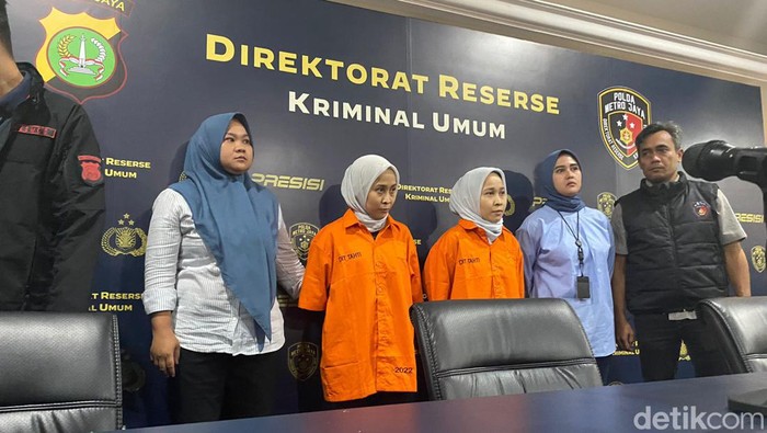 Si kembar penipu, Rihana dan Rihani berbaju tahanan.