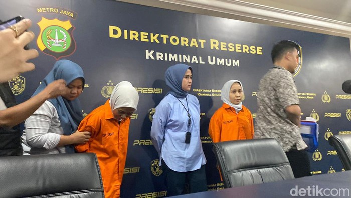 Si kembar penipu, Rihana dan Rihani berbaju tahanan.
