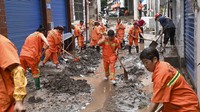 Para pekerja membersihkan jalan yang terhalang oleh tanah longsor. Kementerian keuangan dan manajemen darurat China mengumumkan dana darurat sebesar 320 juta yuan ($44,2 juta) untuk membantu bantuan bencana, termasuk untuk Chongqing. AP/Ran Mengjun