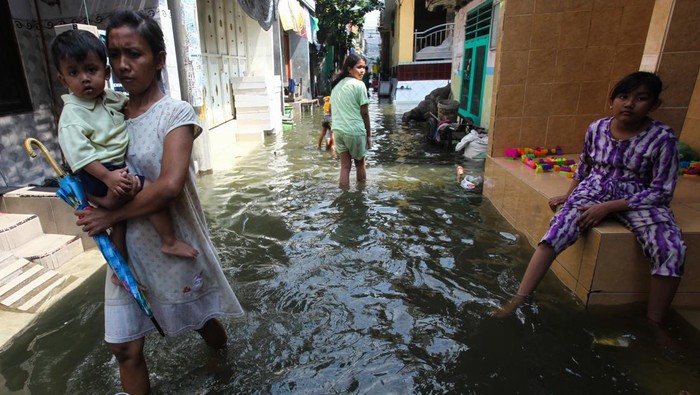 Penjual makanan melayani pembeli saat banjir rob menggenangi kampung Kalianak Timur, Surabaya, Jawa Timur, Rabu (5/7/2023). Pasang air laut yang tinggi akibat adanya fase bulan purnama menyebabkan perkampungan padat penduduk di kawasan tersebut tergenang banjir rob. ANTARA FOTO/Didik Suhartono/foc.