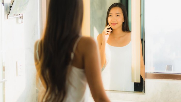 Ilustrasi wanita sedang bercermin.