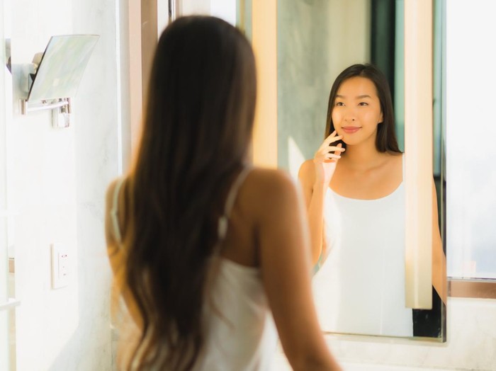 Ilustrasi wanita sedang bercermin.