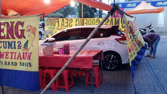Kocak! Potret Mobil yang Terperangkap di Tenda Pecel Lele dan Nasi Uduk