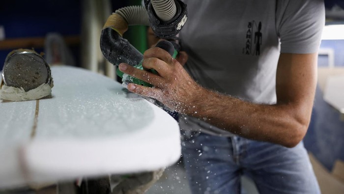 Surfboard and paddle maker Paul Abbas stands in front of his surfboards in progress in his workshop in Halat, north of Beirut, Lebanon June 26, 2023. REUTERS/Emilie Madi