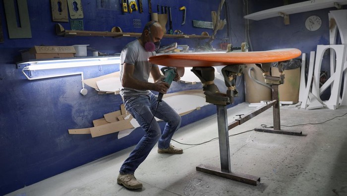 Surfboard and paddle maker Paul Abbas stands in front of his surfboards in progress in his workshop in Halat, north of Beirut, Lebanon June 26, 2023. REUTERS/Emilie Madi