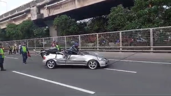 Mobil Honda Estilo terbalik hingga ringsek usai tabrak tiang lampu di Tol Wiyoto Wiyono, Kelapa Gading, Rabu (5/7/2023) sore.