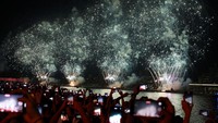 Warga yang datang tidak ingin melewatkan momen pesta kembang api tersebut. Mereka mengabadikan momen itu menggunakan kamera ponselnya. Reuters/Amr Alfiky.