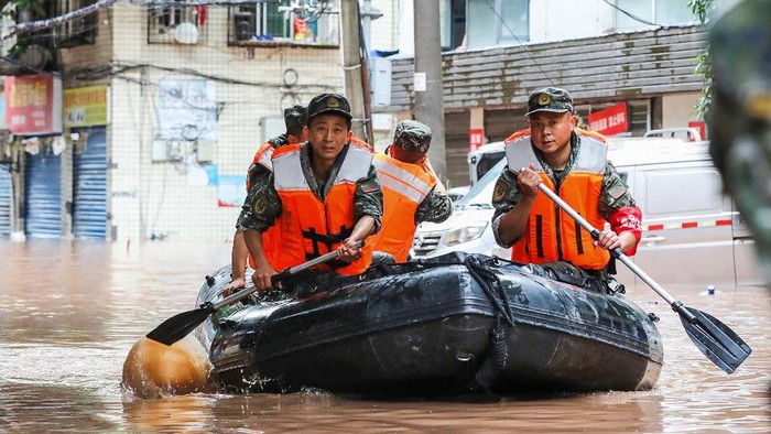 (FILES) This file photo taken on July 4, 2023 shows paramilitary policemen searching an area after it was flooded by heavy rains in Chinas southwestern Chongqing. Fifteen people have been killed and four are missing after torrential rain in southwest China, state media said on July 5, 2023. (Photo by AFP) / China OUT
